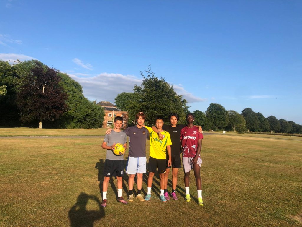A group of five male Langley boarders outside on a sunny day  on the Langley grounds 